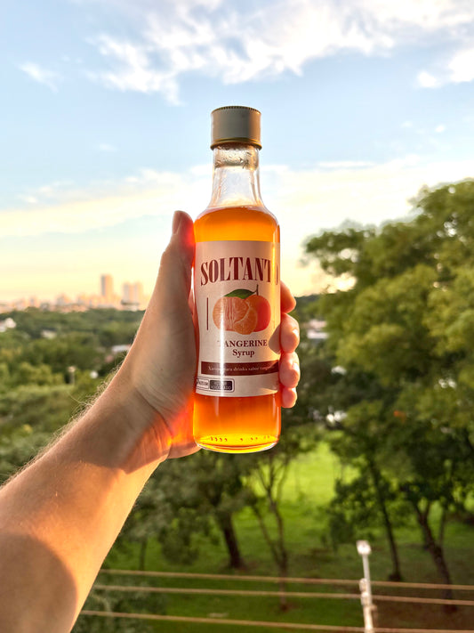 Xarope de tangerina sendo segurado na mão