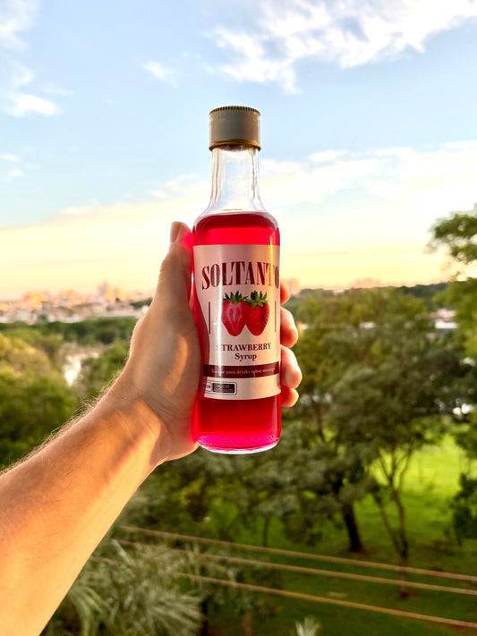 Xarope de morango sendo sendo segurado na mão