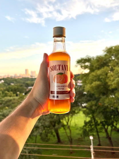 Xarope de tangerina sendo segurado na mão